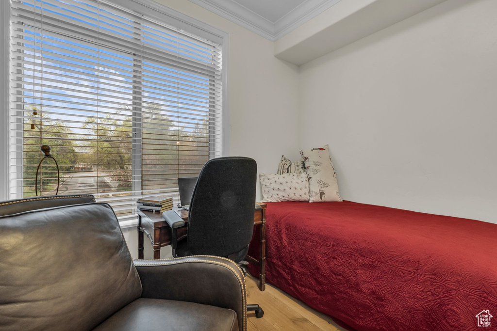 Bedroom featuring crown molding, wood finished floors, and an office area