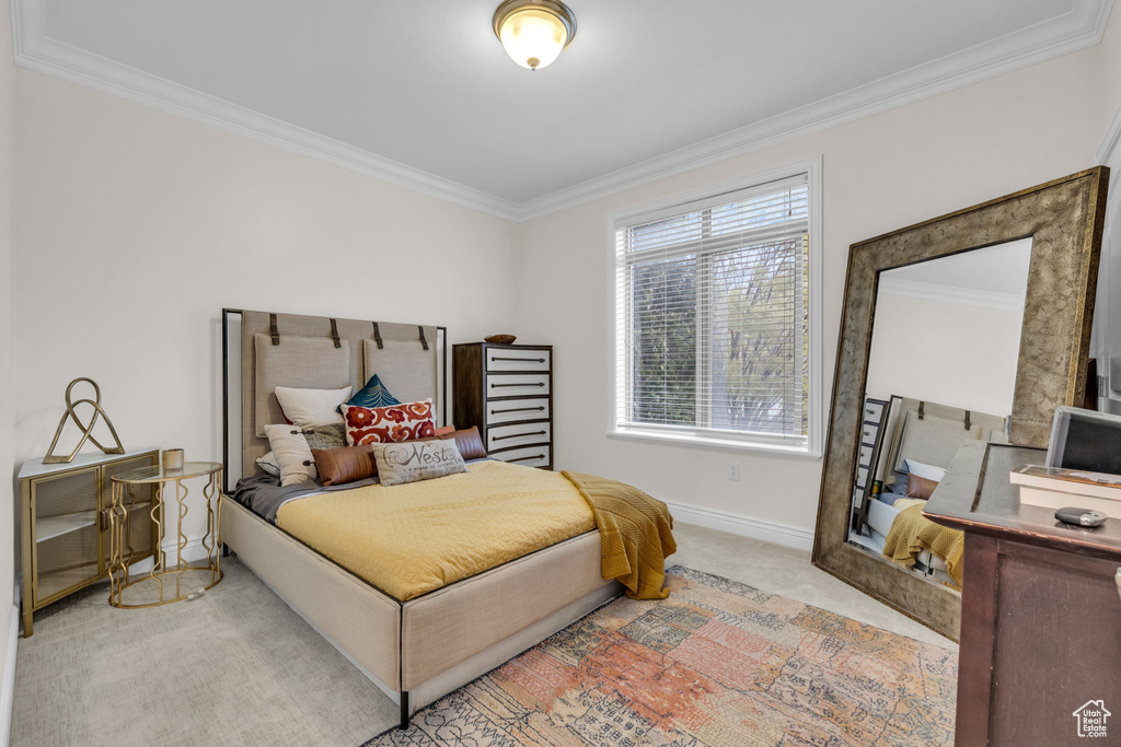 Bedroom featuring crown molding and light carpet