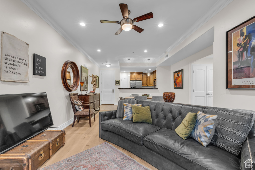 Living area with crown molding, light wood-style floors, ceiling fan, and recessed lighting