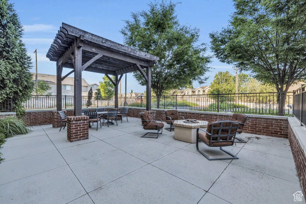 Fenced backyard with an outdoor fire pit, a patio area, a pergola, and outdoor dining space