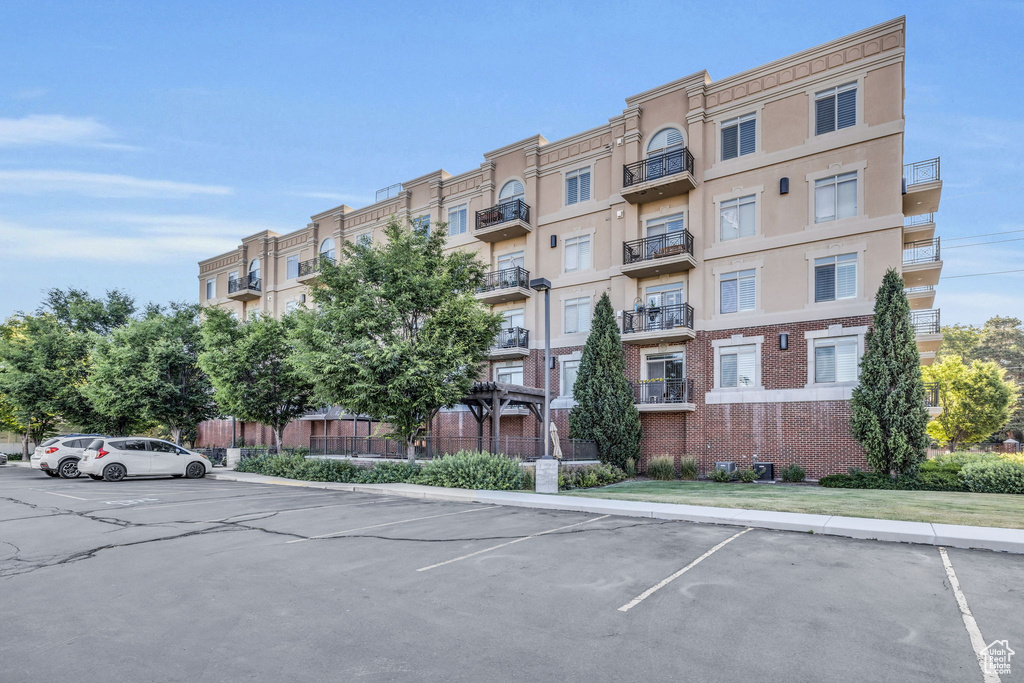 View of apartment building / complex with uncovered parking