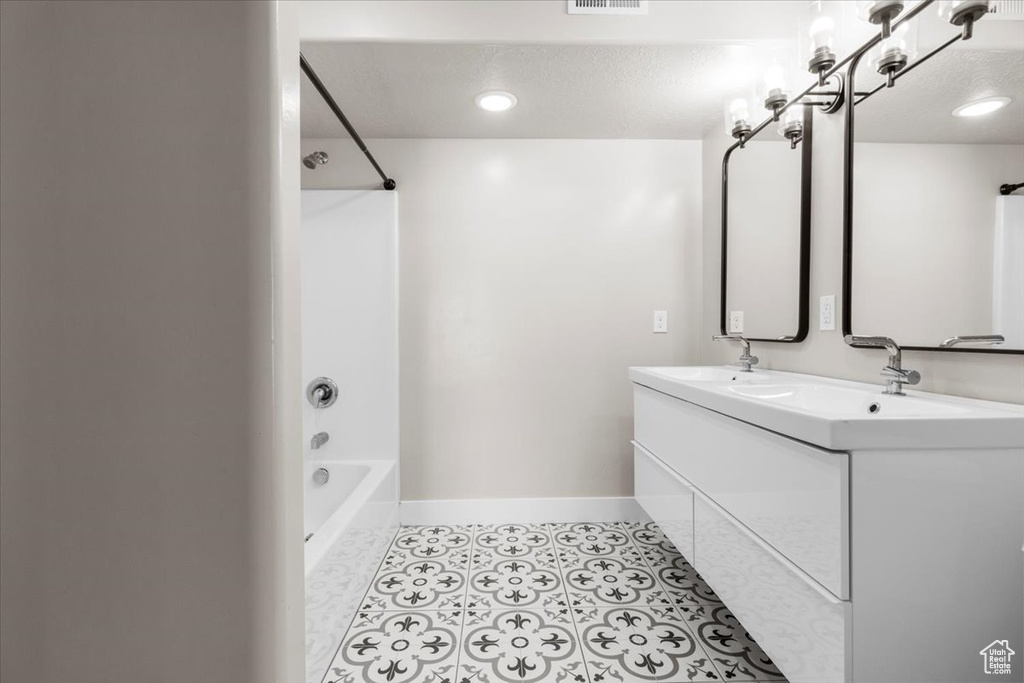 Bathroom with double vanity and bathing tub / shower combination