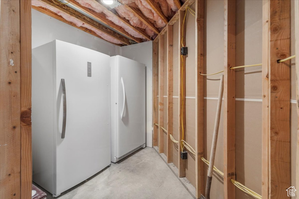 Unfinished basement featuring freestanding refrigerator