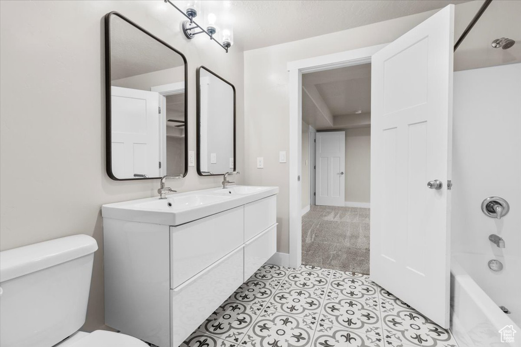 Bathroom featuring double vanity, shower / tub combination, and tile patterned floors