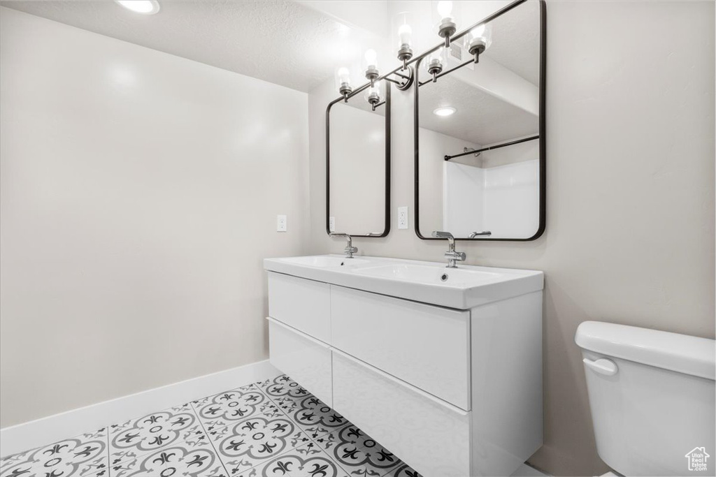 Full bathroom with double vanity and tile patterned flooring