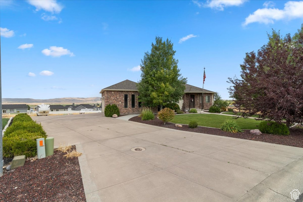 View of front of home with driveway, a front lawn, and brick siding