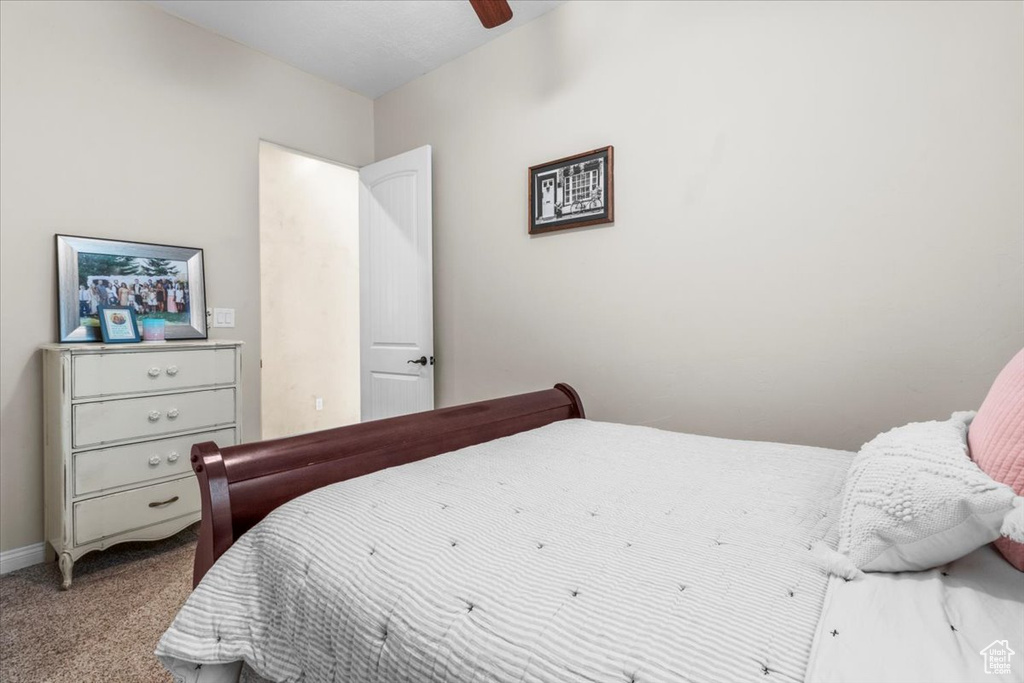 Carpeted bedroom with a ceiling fan
