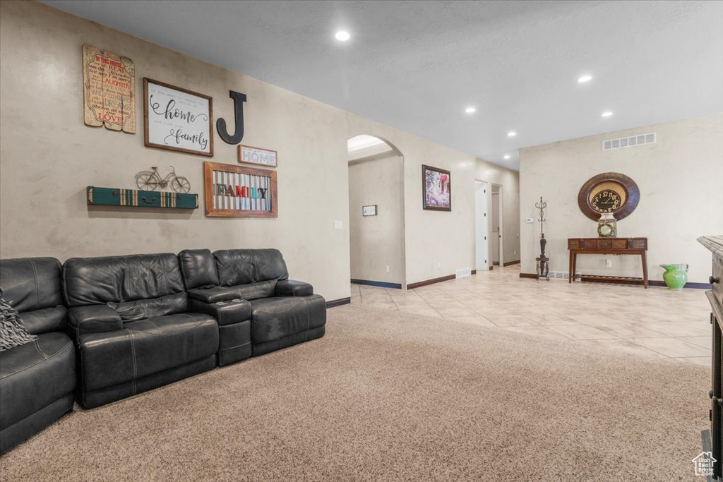 Living area featuring arched walkways, recessed lighting, light colored carpet, and light tile patterned flooring