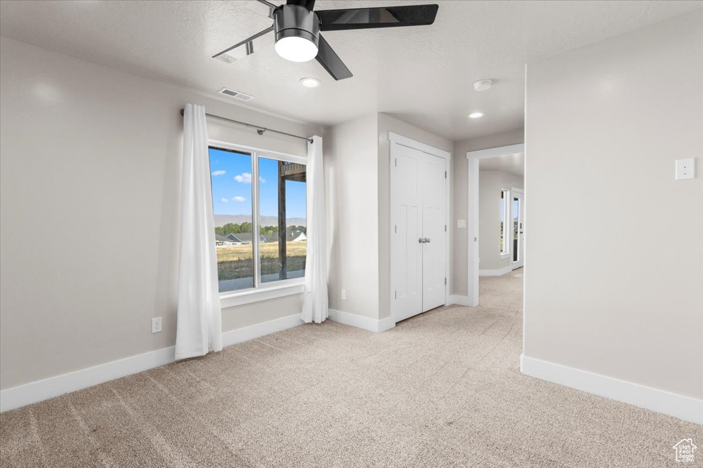 Spare room with a ceiling fan, carpet flooring, and recessed lighting