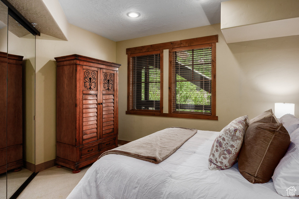 Carpeted bedroom featuring a textured ceiling and recessed lighting