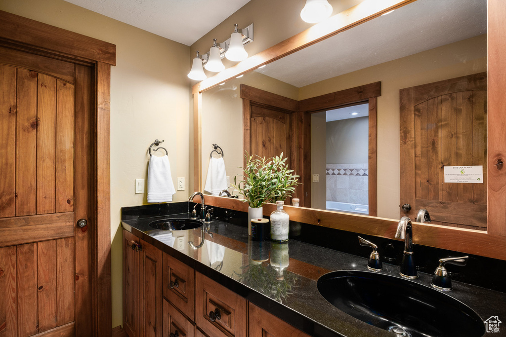 Bathroom featuring double vanity and a bath