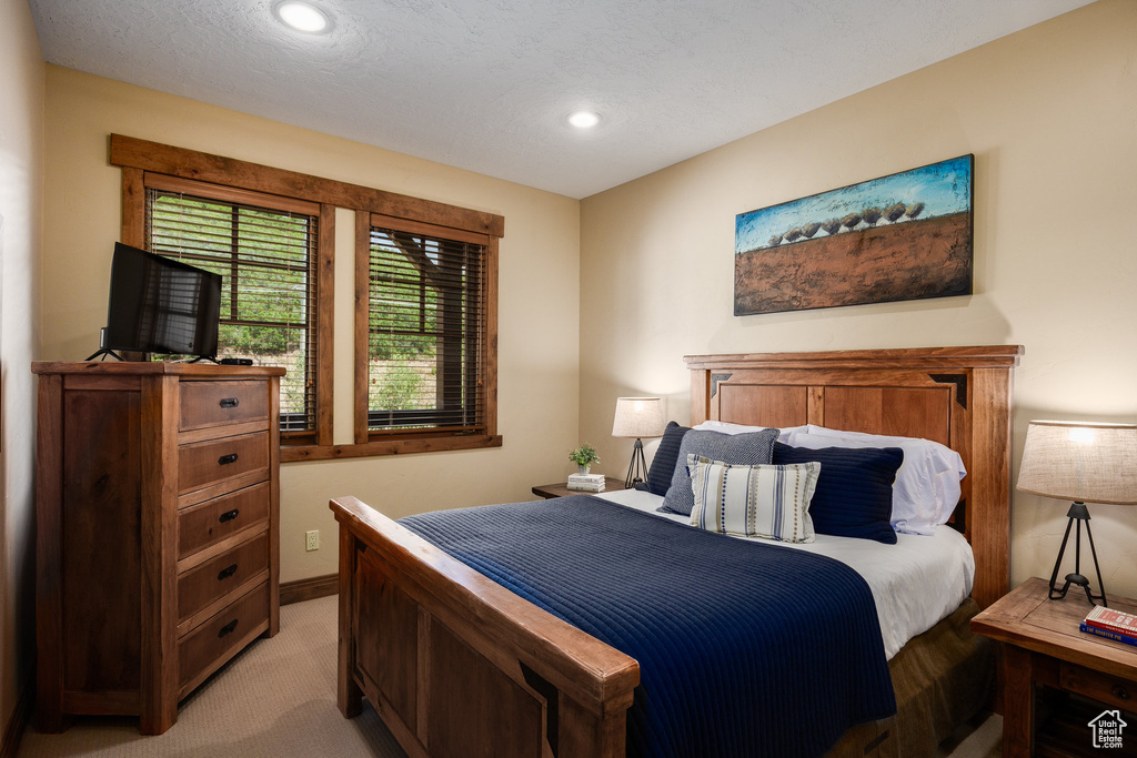 Bedroom with light colored carpet and recessed lighting