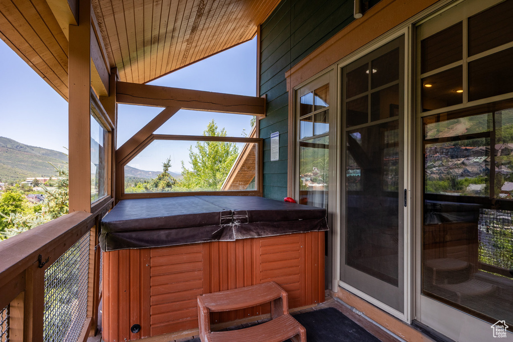 Deck with a hot tub and a mountain view