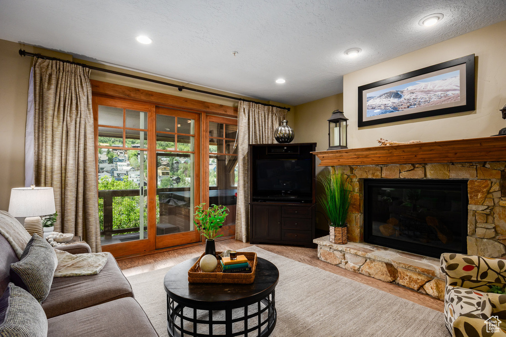 Living area with a fireplace, recessed lighting, and a textured ceiling