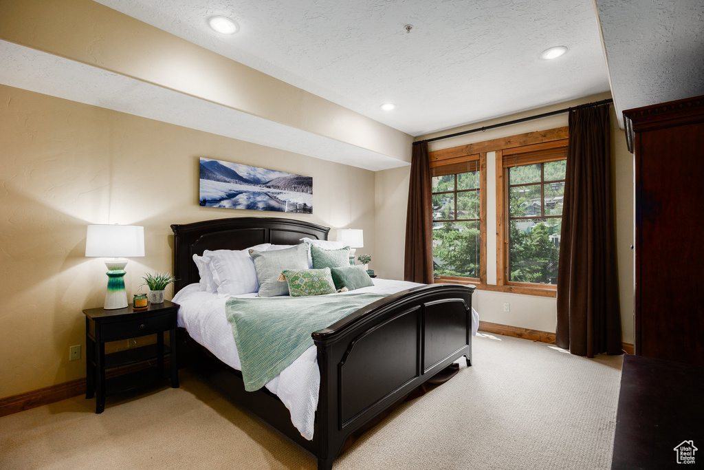 Bedroom with light carpet, recessed lighting, and a textured ceiling
