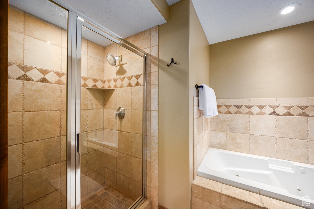 Full bath featuring a tub with jets and a shower stall