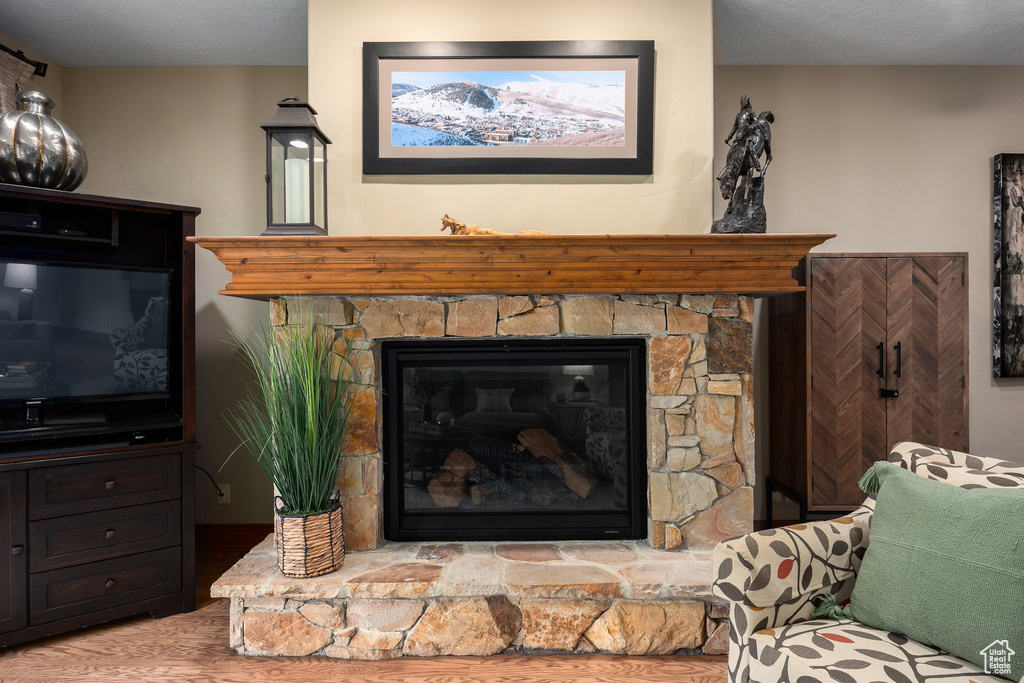 Detailed view of wood finished floors and a stone fireplace
