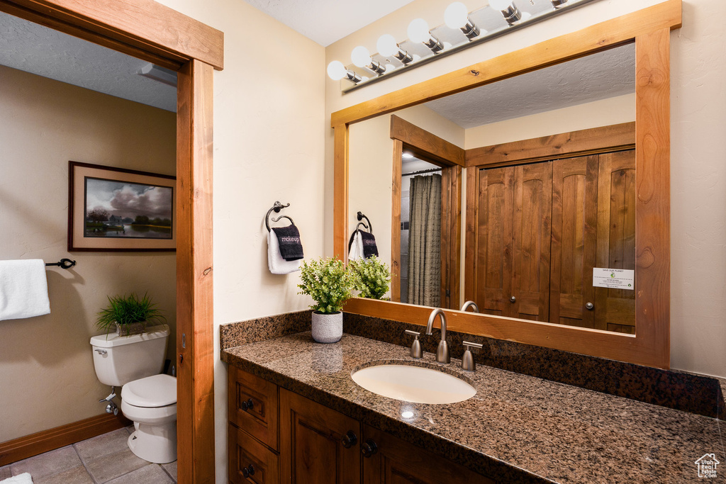 Full bath with vanity and tile patterned flooring