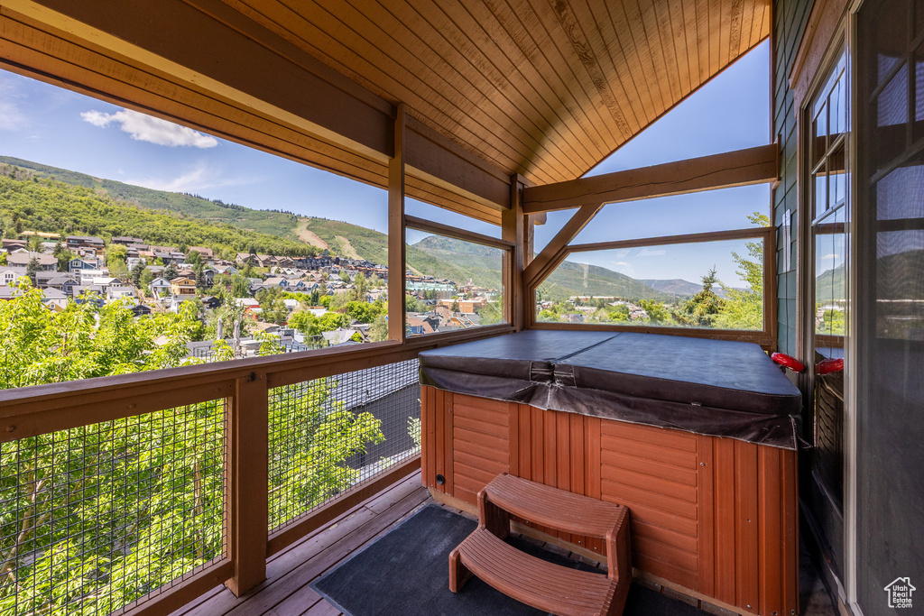 Wooden terrace with a hot tub and a mountain view