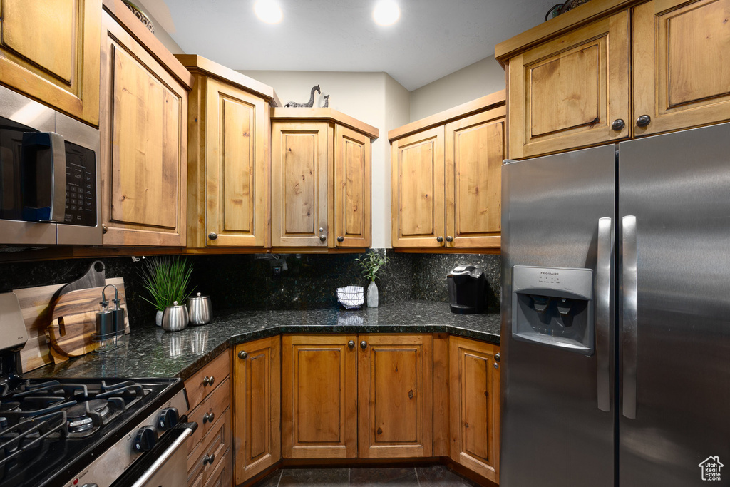 Kitchen featuring appliances with stainless steel finishes, backsplash, and brown cabinets