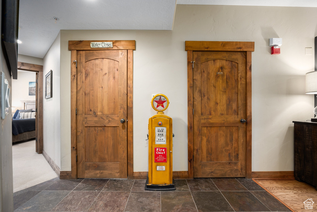 Foyer entrance featuring baseboards and dark stone finish flooring