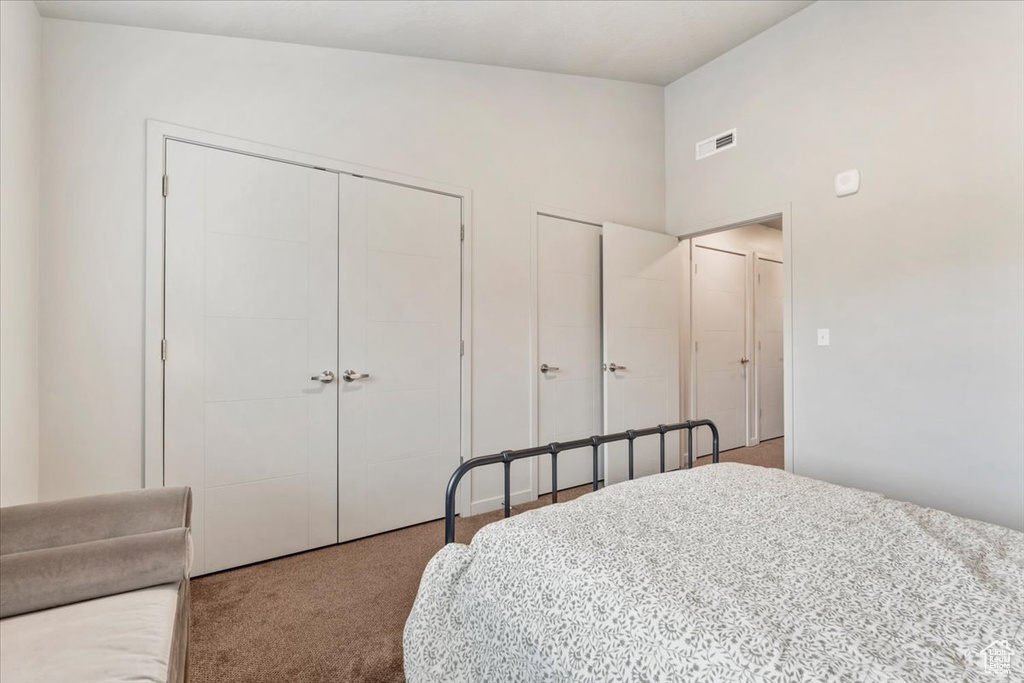 Bedroom with carpet floors and vaulted ceiling