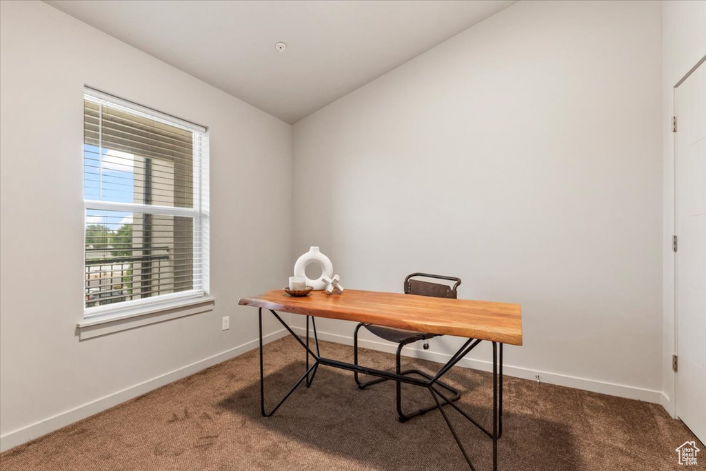 Carpeted office space featuring baseboards and lofted ceiling