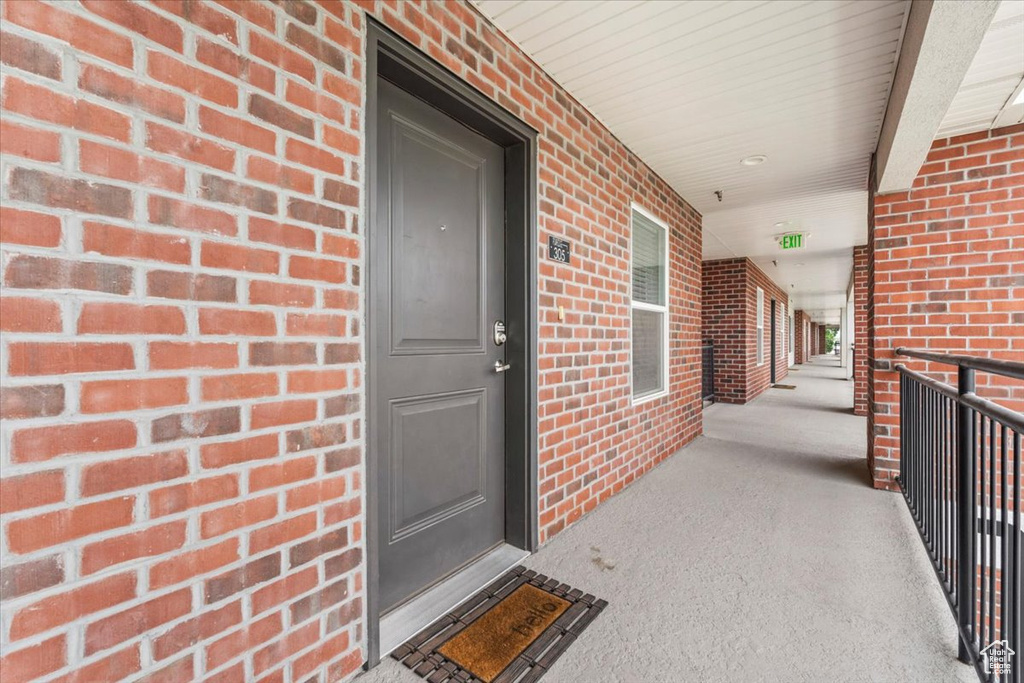 Entrance to property with brick siding and a porch