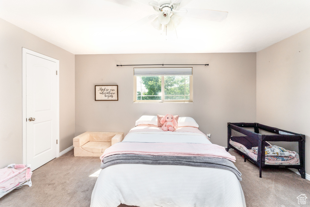 Bedroom featuring light colored carpet and a ceiling fan