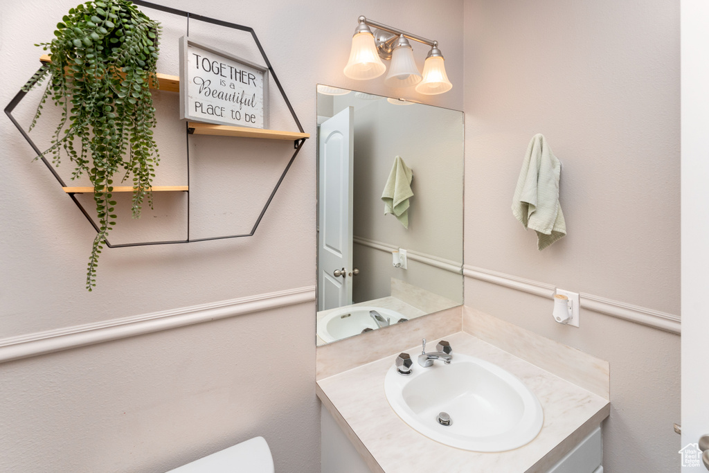 Half bathroom featuring vanity and toilet