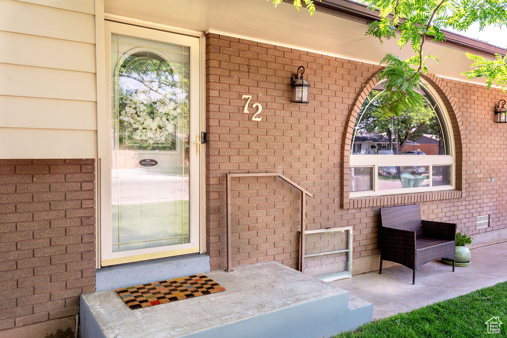 View of exterior entry with brick siding