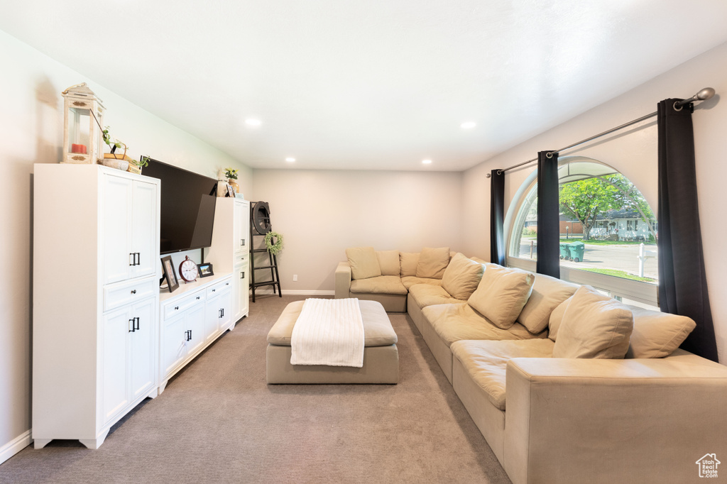Living area with light colored carpet and recessed lighting