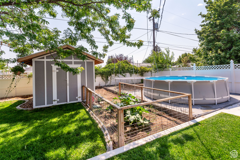 Fenced backyard with a storage unit and a vegetable garden