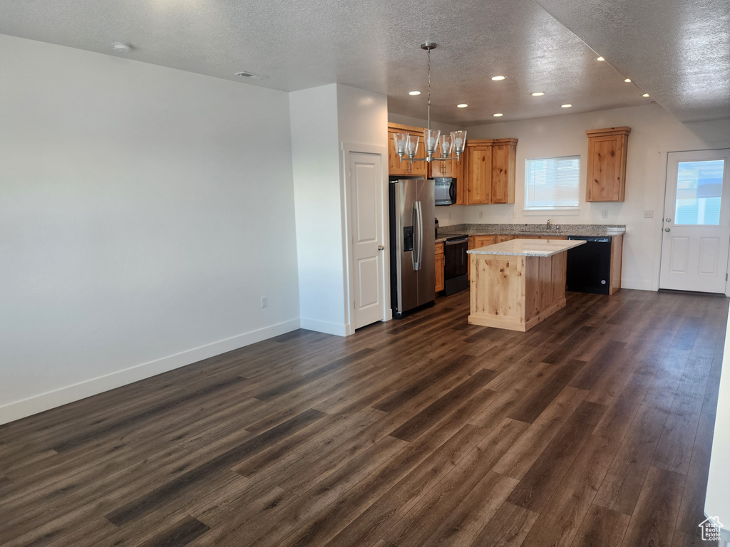 Kitchen with recessed lighting, black appliances, a center island, a textured ceiling, and dark wood-type flooring