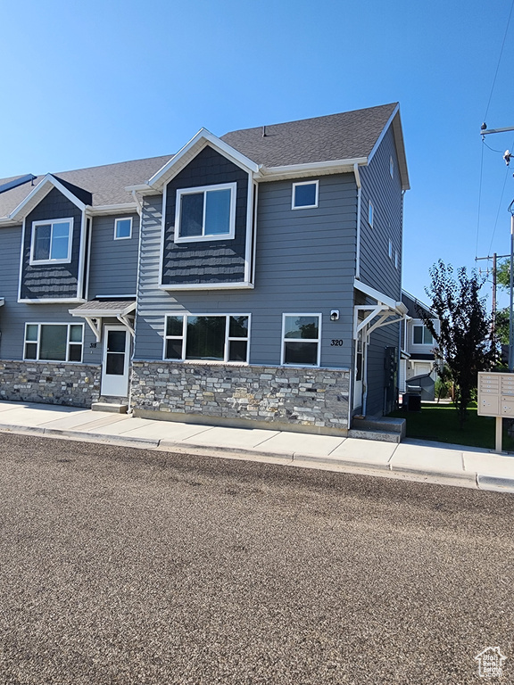 Craftsman inspired home with stone siding and roof with shingles