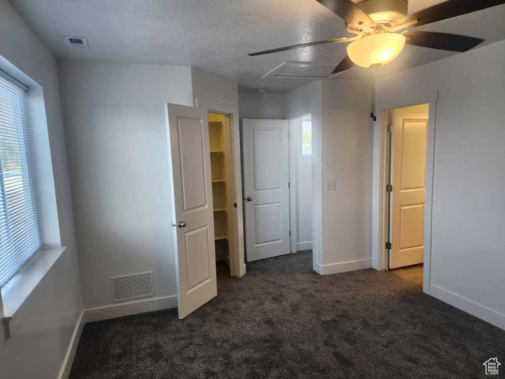 Unfurnished bedroom with carpet floors, multiple windows, and ceiling fan