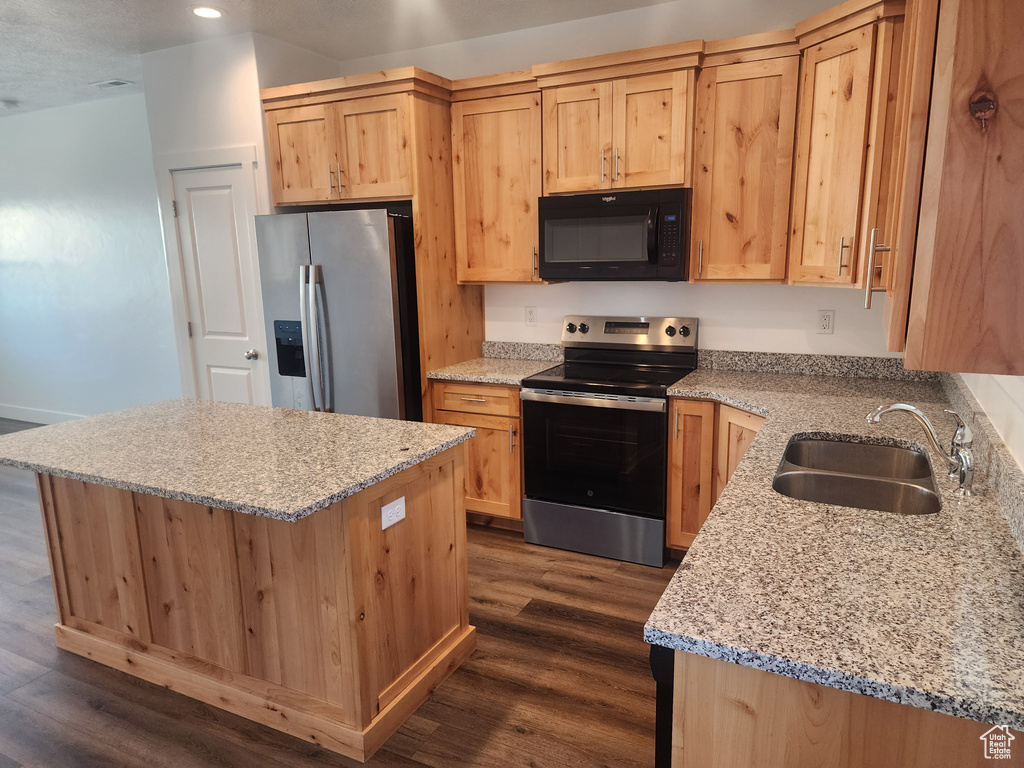 Kitchen featuring appliances with stainless steel finishes, light brown cabinets, dark wood-style flooring, and recessed lighting