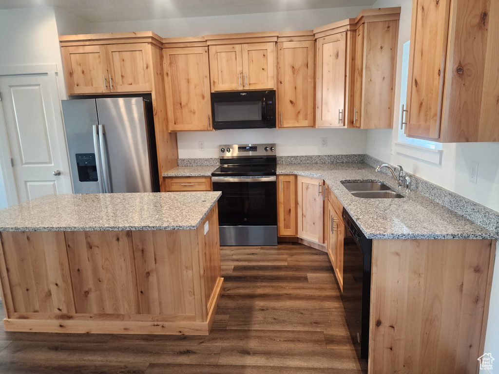 Kitchen with light brown cabinets, black appliances, dark wood-type flooring, a center island, and light stone countertops