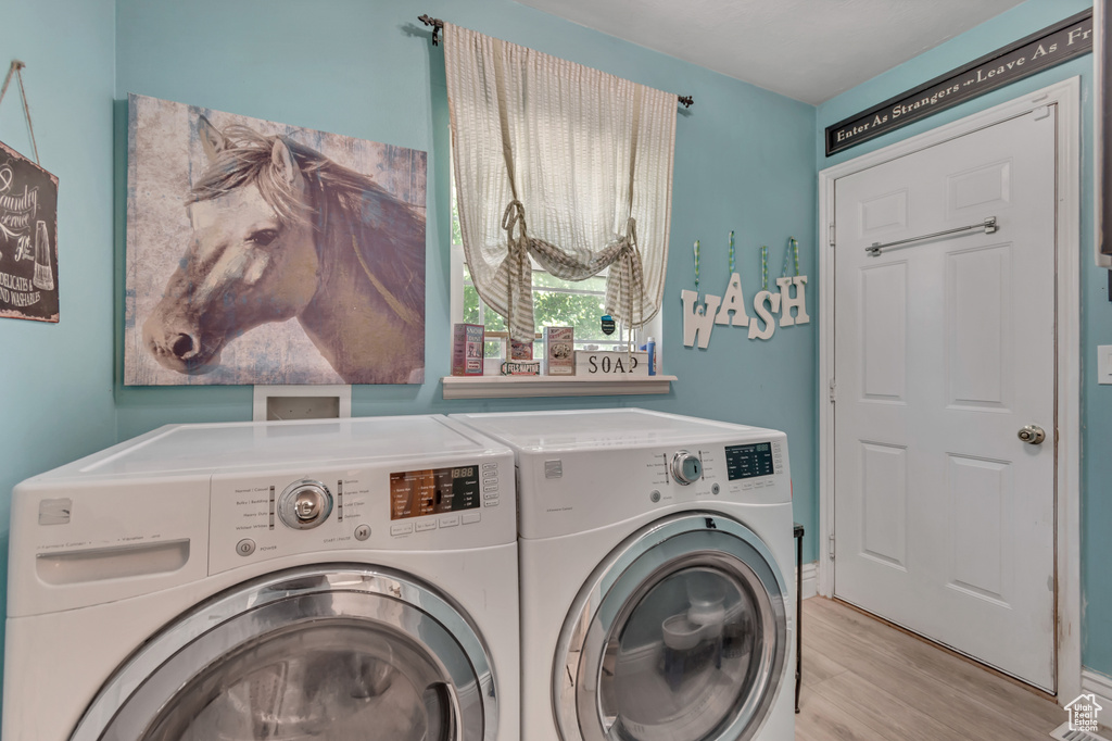Laundry room featuring separate washer and dryer and light wood-style flooring