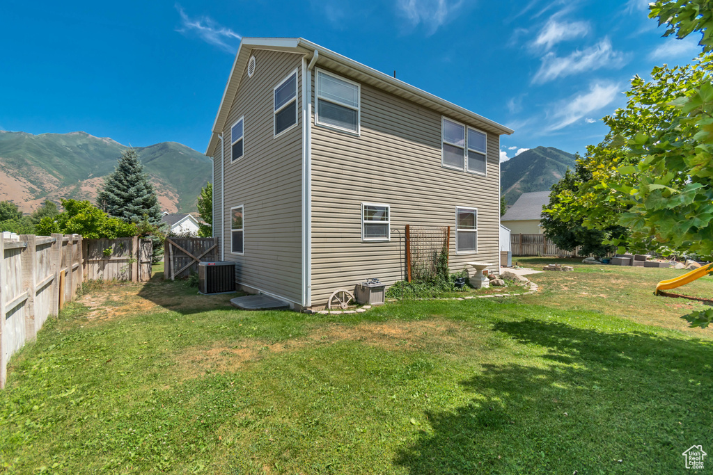 Rear view of property with a mountain view and a fenced backyard