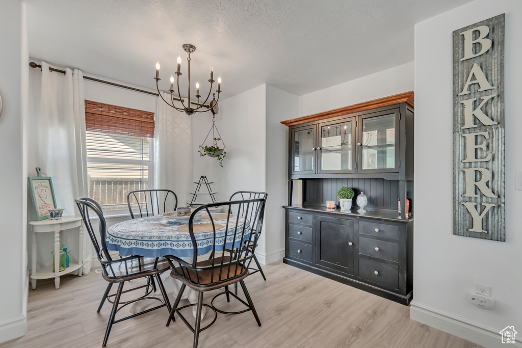 Dining area with a chandelier and light wood-style floors