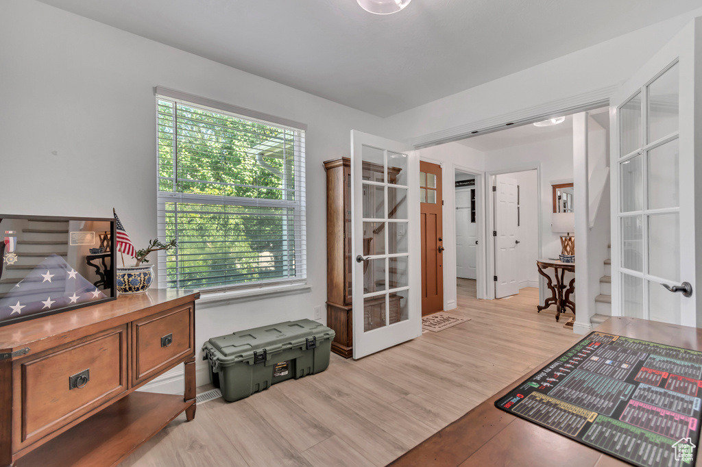 Office space with french doors and light wood-type flooring