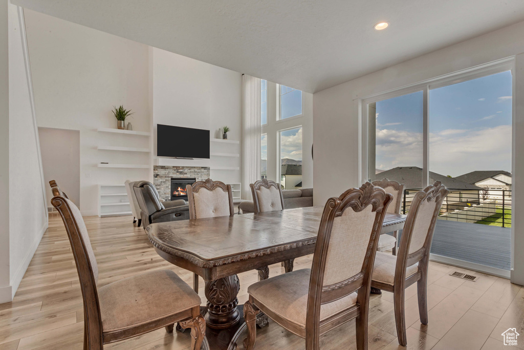 Dining space featuring a fireplace, healthy amount of natural light, built in shelves, recessed lighting, and light wood-type flooring