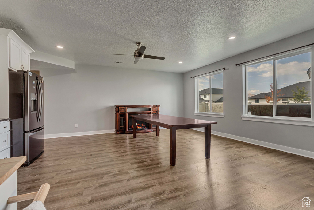 Dining space with wood finished floors, ceiling fan, recessed lighting, and a textured ceiling