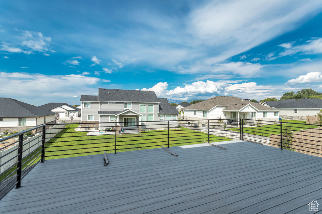 Wooden deck with a residential view and a yard