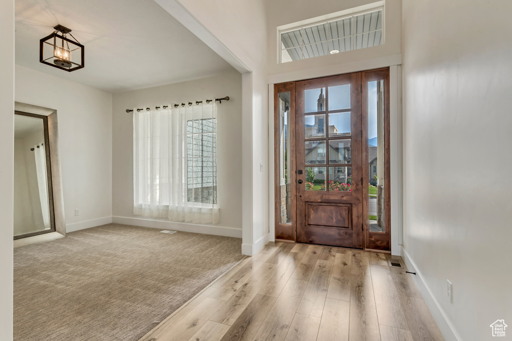 Entrance foyer featuring wood finished floors and a chandelier