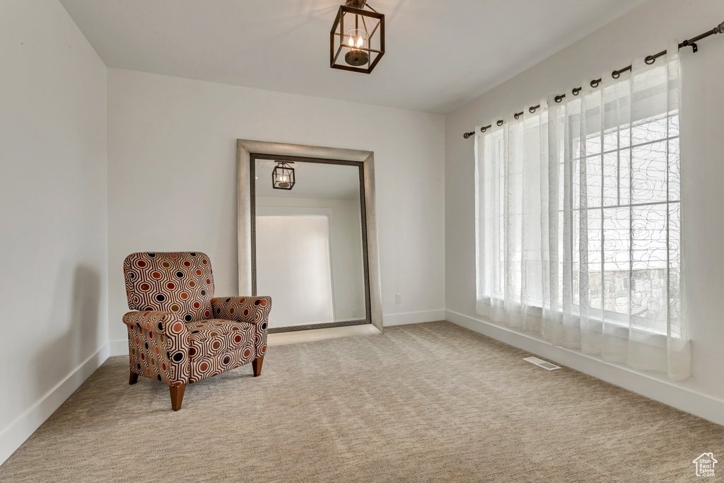 Sitting room with carpet floors and a chandelier