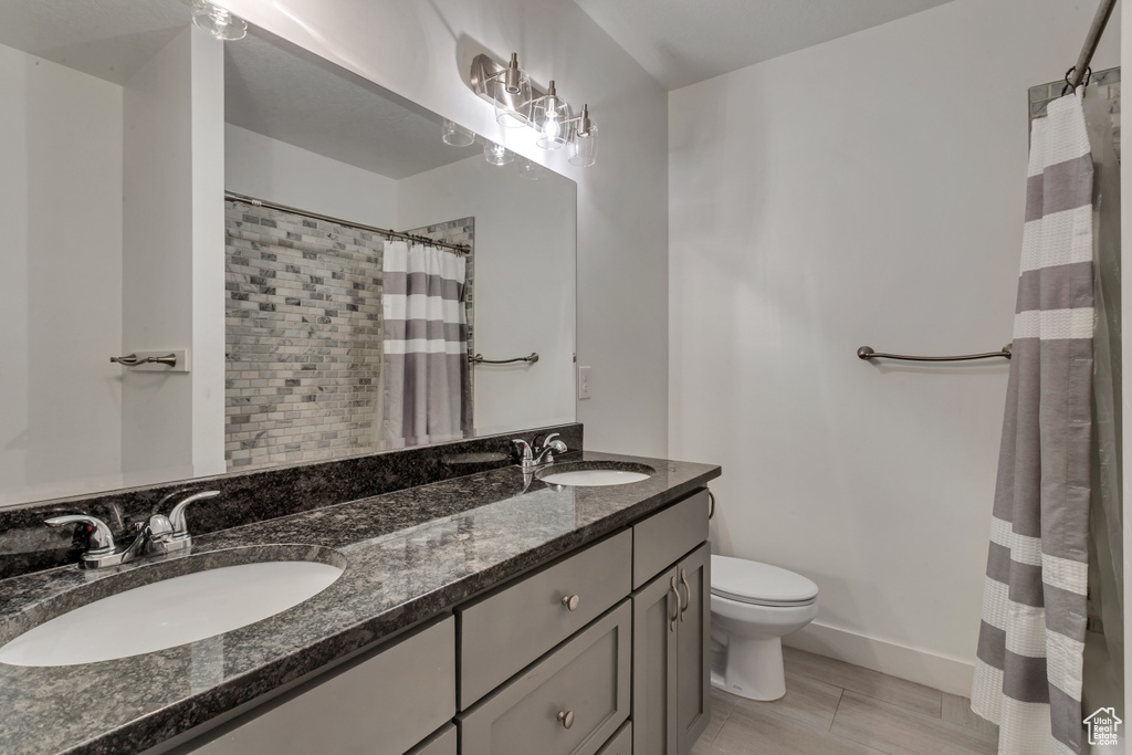 Full bathroom with double vanity and a shower with shower curtain