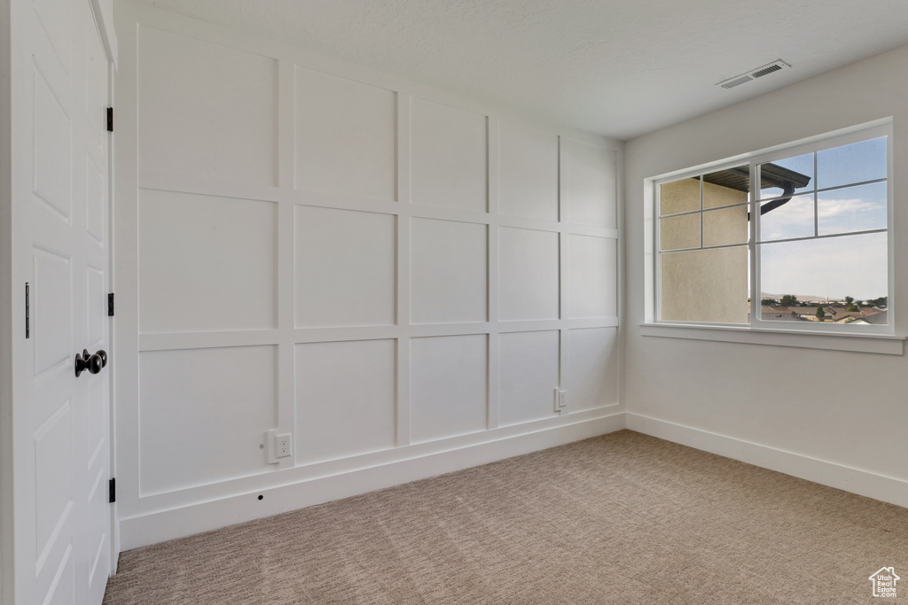 Carpeted empty room featuring baseboards