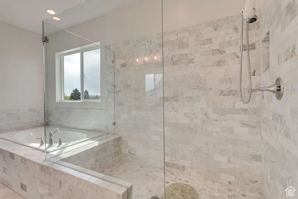 Bathroom with a tile shower, a bath, and recessed lighting